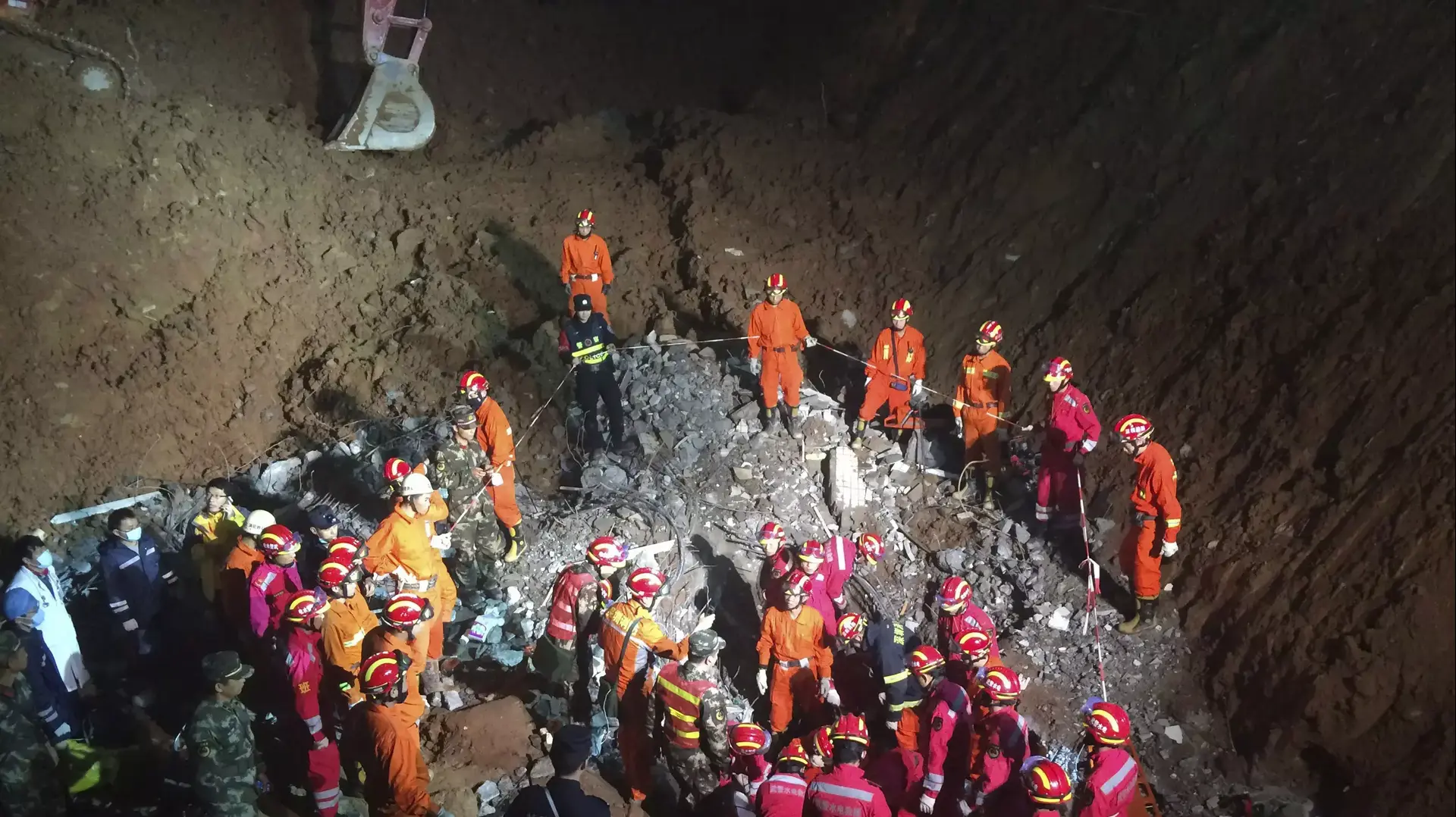 צוותי חילוץ סביב נער שחולץ מהריסות בעיר שנג'ן, סין, אחרי 60 שעות, 23 בדצמבר 2015
