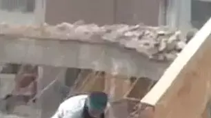 פועל הורס חומה שעומד עליה