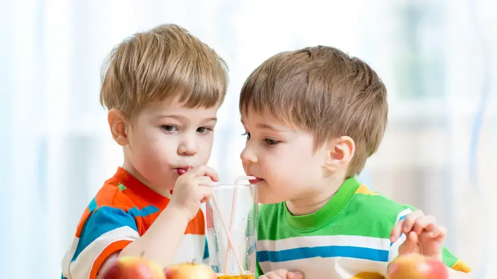 ילדים שותים מיץ תפוחים ילדים שותים מיץ תפוחים