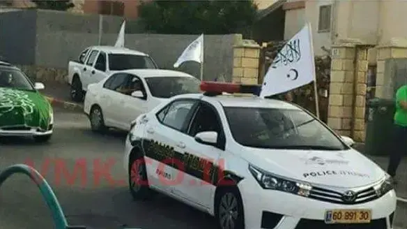 שוטר בתוך ניידת מניף את דגל התנועה האיסלאמית, טובה זנגריה. 5 ביוני 2016