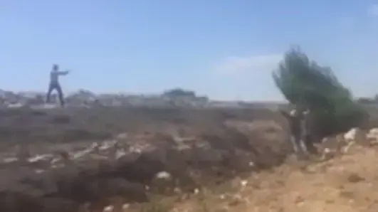 מתנחל רעול פנים מכוון את אקדחו לעבר שני פלסטיניים ליד המאחז דרך האבות שבגוש עציון, יולי 2016 מתנחל רעול פנים מכוון את אקדחו לעבר שני פלסטיניים ליד המאחז דרך האבות שבגוש עציון, יולי 2016