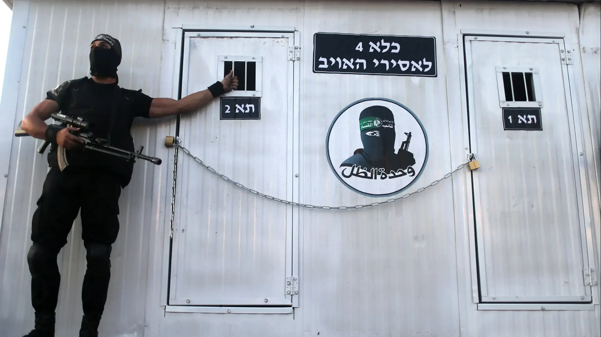 איש גדודי עז א-דין אל קסאם  הזרוע הצבאית של חמאס מציג תא כלא אשר מיועד כביכול לשבויים ישראלים בעת מצעד נגד ישראל ברפיח