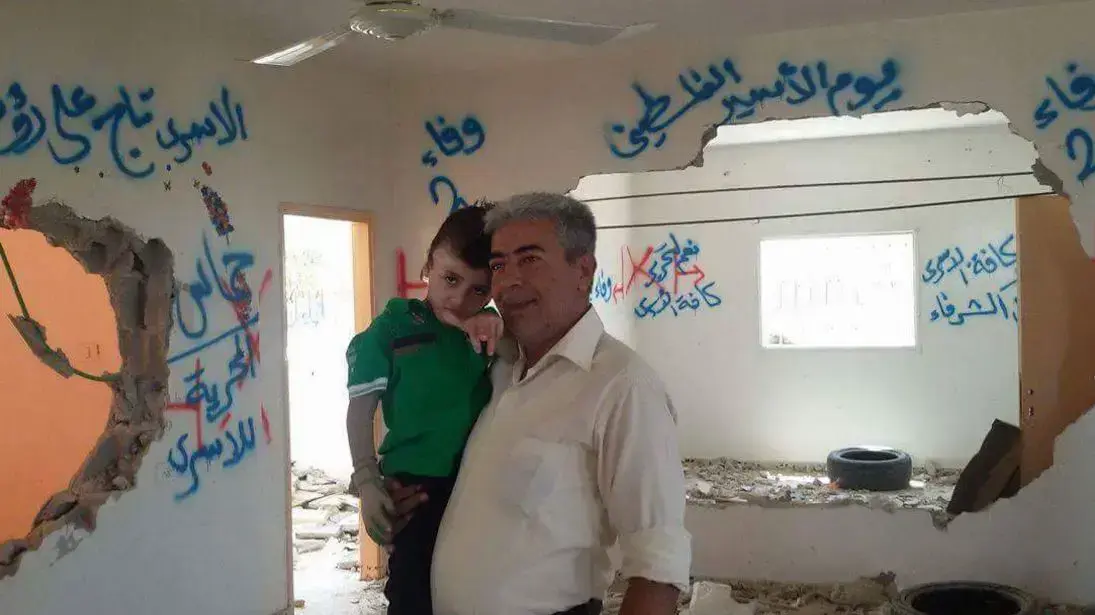 הילד אחמד דוואבשה בביקור בבית ההרוס של משפחת מחבל בכפר דיר סאמת שליד חברון, אוגוסט 2016
