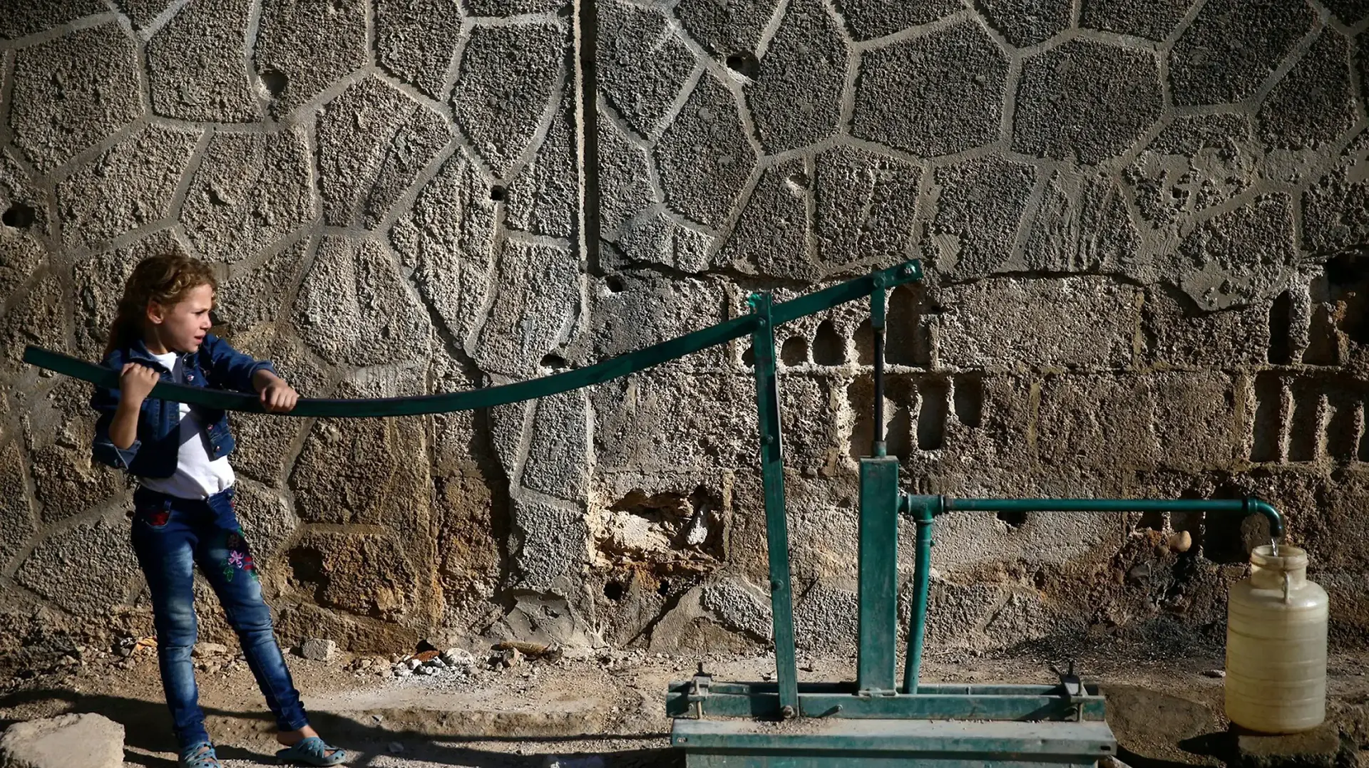 ילדה שואבת מים בפרברי דמשק, סוריה, 12 בספטמבר 2016