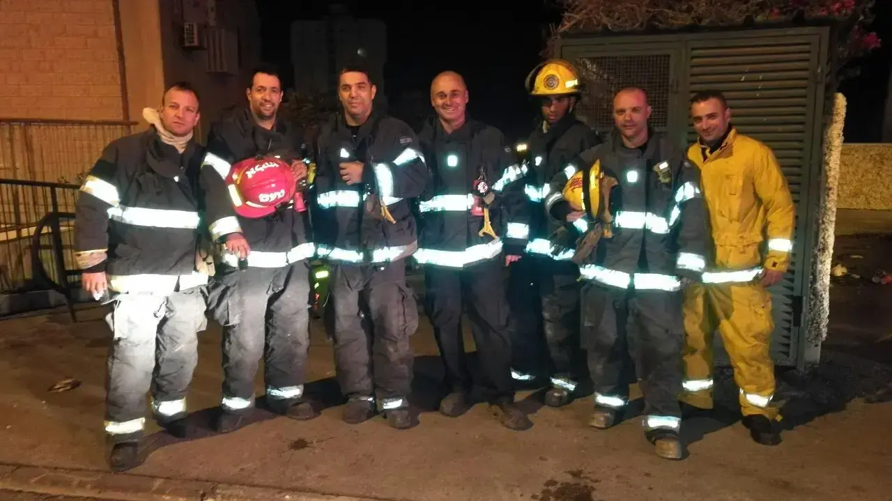כבאי יחד עם הכלבה שהוא הציל במהלך השריפה בחיפה, 25 בנובמבר 2016