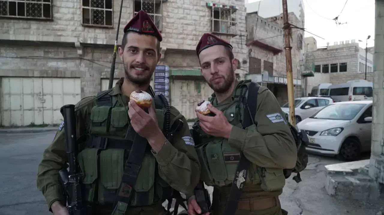 לוחמי גדוד 890 של חטיבת הצנחנים אוכלים סופגניות בגזרת חברון, דצמבר 2016 לוחמי גדוד 890 של חטיבת הצנחנים אוכלים סופגניות בגזרת חברון, דצמבר 2016