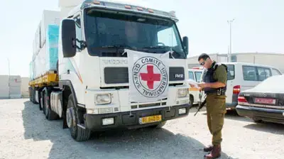 משאית סיוע נבדקת על ידי חייל במעבר ארז