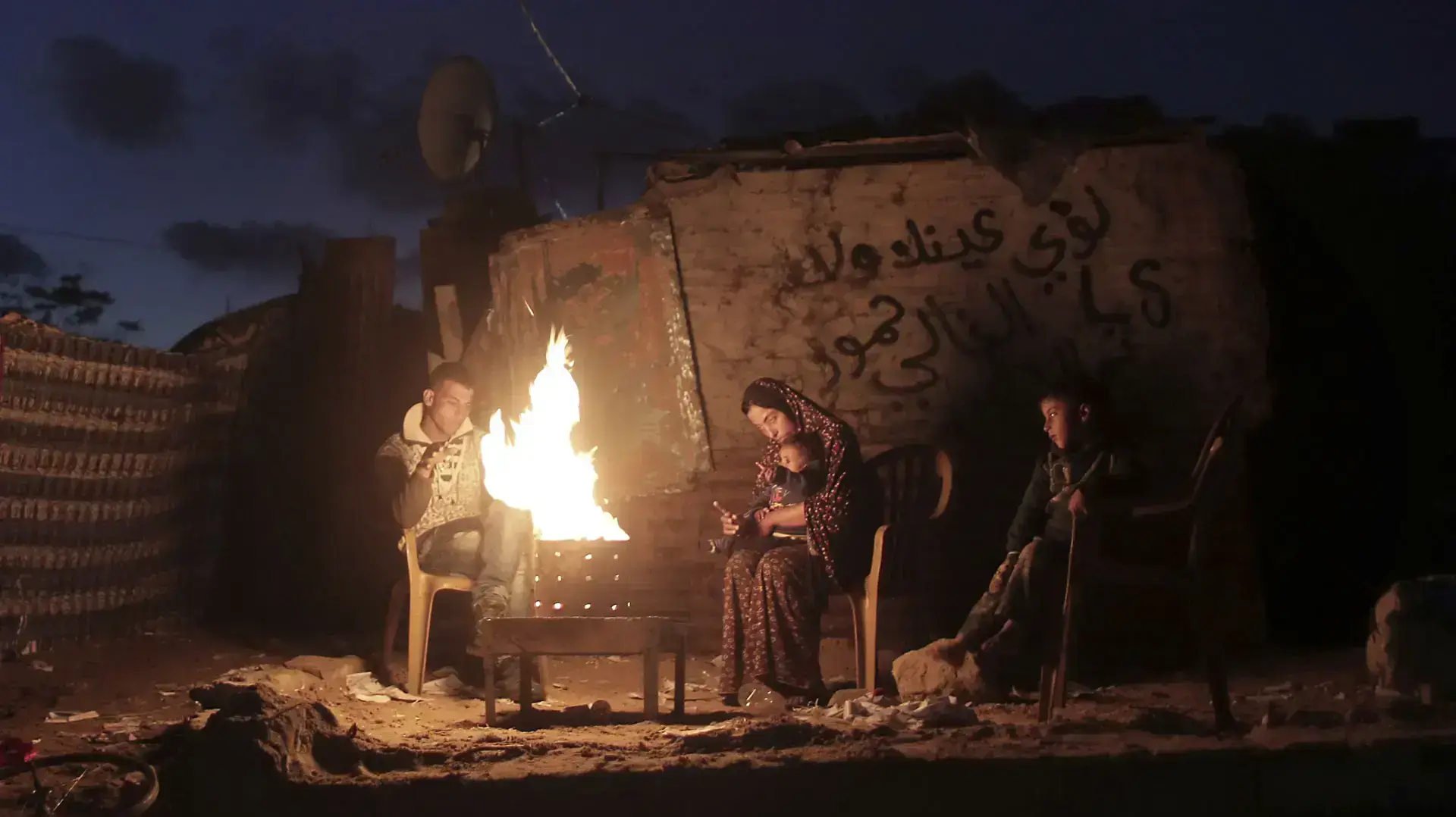 משפחה יושבת סביב מדורה בזמן הפסקת חשמל בחאן יונס עזה, ינואר 2017 משפחה יושבת סביב מדורה בזמן הפסקת חשמל בחאן יונס עזה, ינואר 2017