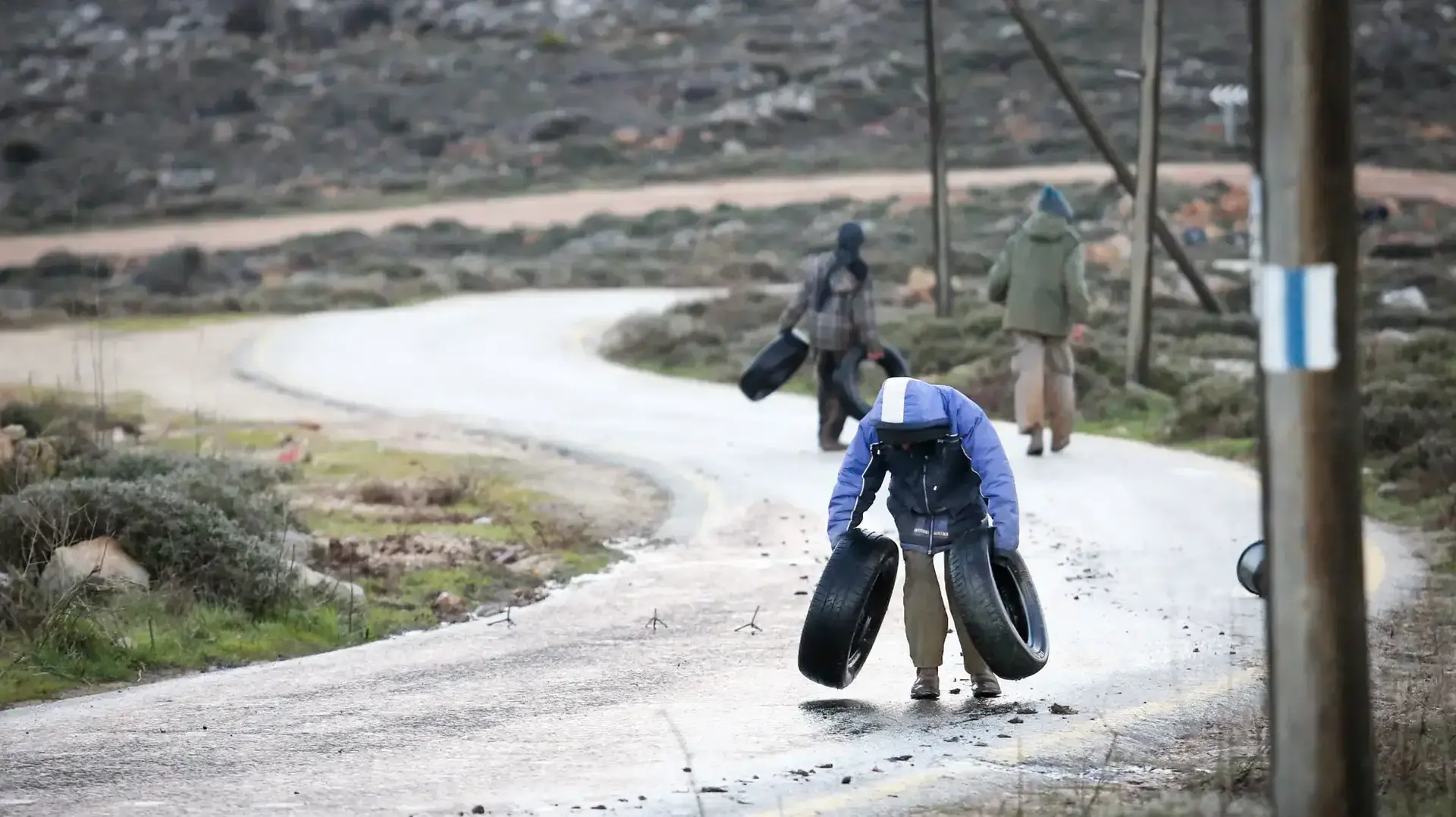 צעירים מחזקים את החסימות בכביש הגישה למאחז עמונה בבוקר הפינוי המיועד, 1 בפברואר 2017 צעירים מחזקים את החסימות בכביש הגישה למאחז עמונה בבוקר הפינוי המיועד, 1 בפברואר 2017