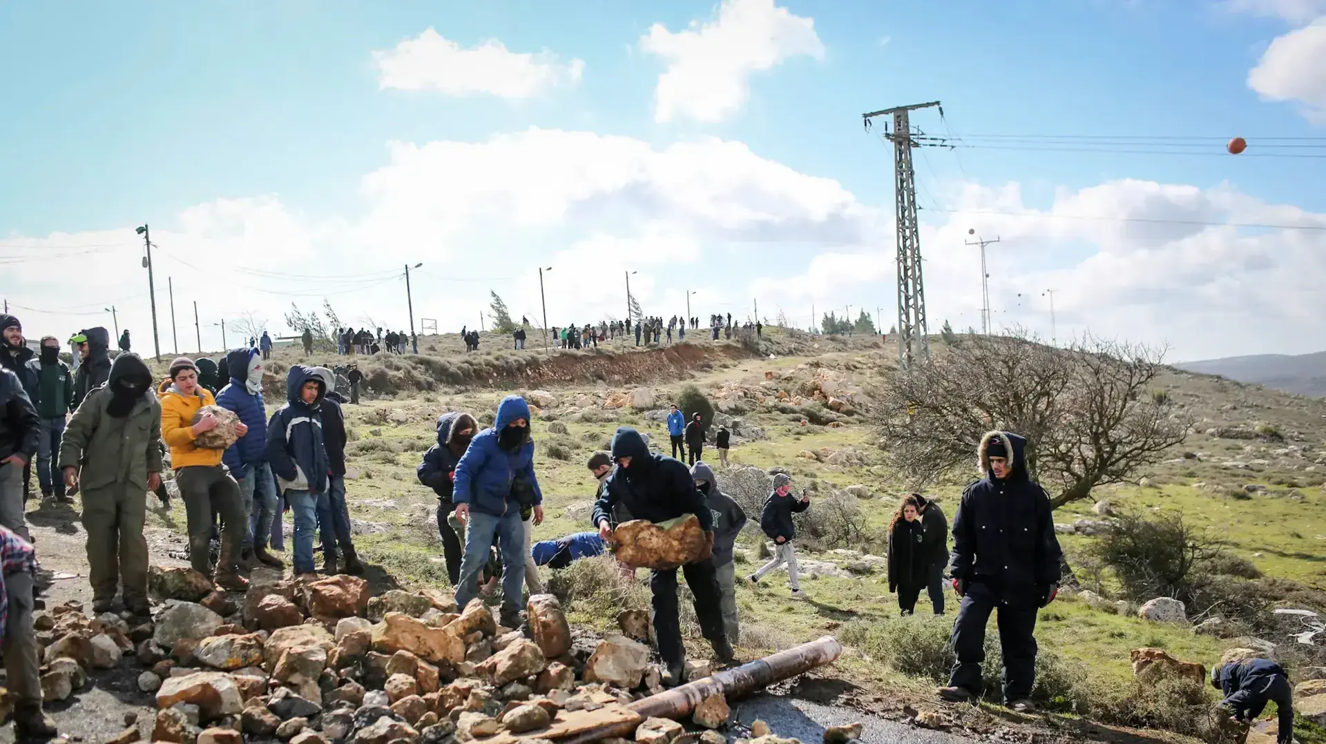 נערים מתאספים מתחת למאחז עמונה וצופים על השוטרים העולים לפינוי המאחז, 1 בפברואר 2017 נערים מתאספים מתחת למאחז עמונה וצופים על השוטרים העולים לפינוי המאחז, 1 בפברואר 2017