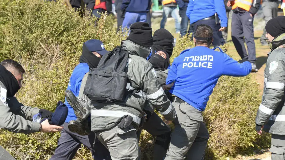 שוטר מפונה מבית הכנסת בו מתבצרים מתנגדי פינוי המאחז עמונה, 2 בפברואר 2017 שוטר מפונה מבית הכנסת בו מתבצרים מתנגדי פינוי המאחז עמונה, 2 בפברואר 2017