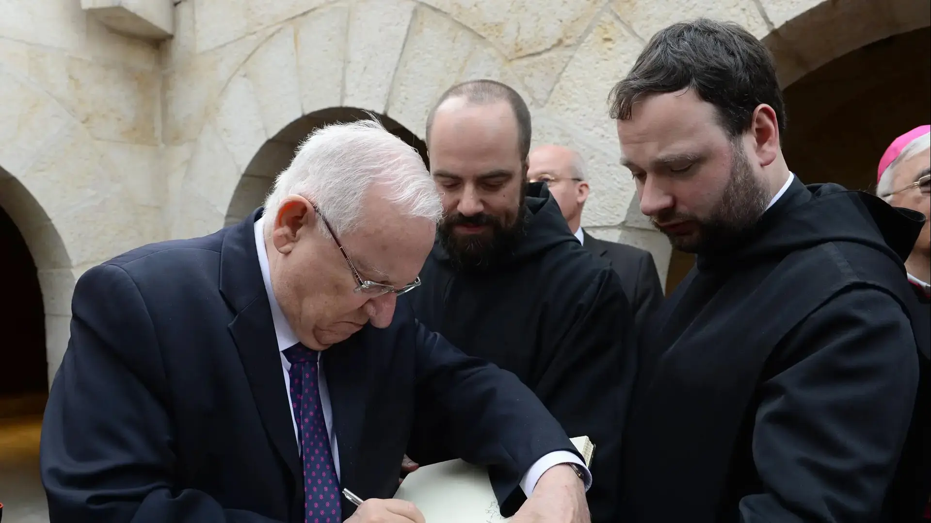 נשיא המדינה ראובן ריבלין חותם על ספר אורחים בכנסיית הלחם והדגים ששופצה לאחר בוצתה ב-2015, 12 בפברואר 2017