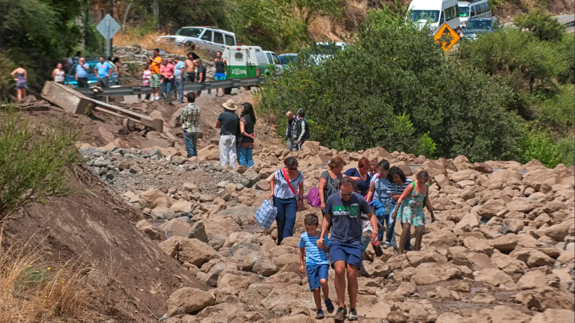תושבים צועדים ליד כביש בבירת צ'ילה, סנטיאגו, שנפגע משיטפונות, 26 בפברואר 2017