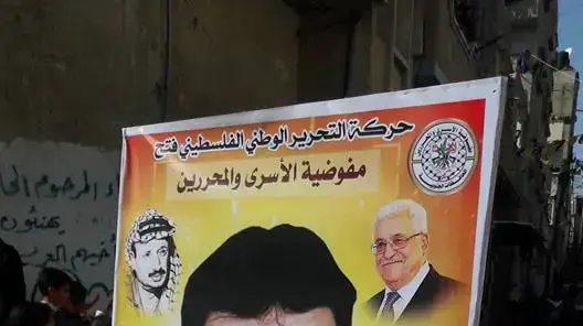 שלטים עם תמונתו של חאתם מרארי שוטר פלסטיני שהורשע בהכאתם למוות של שני אנשי מילואים במהלך הלינץ' ברמאללה, מרץ 2017