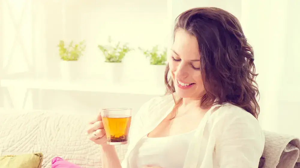אישה בהריון שותה כוס תה
