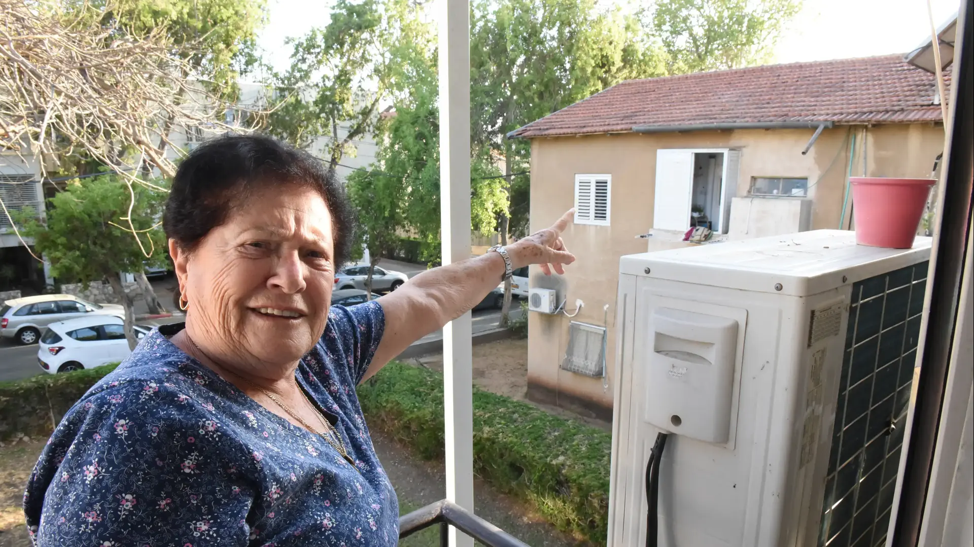 מלכה מנצי גלעד מצביעה על הבית שנפגע בהפגזת תל אביב במחלמת ששת הימים מלכה מנצי גלעד מצביעה על הבית שנפגע בהפגזת תל אביב במחלמת ששת הימים