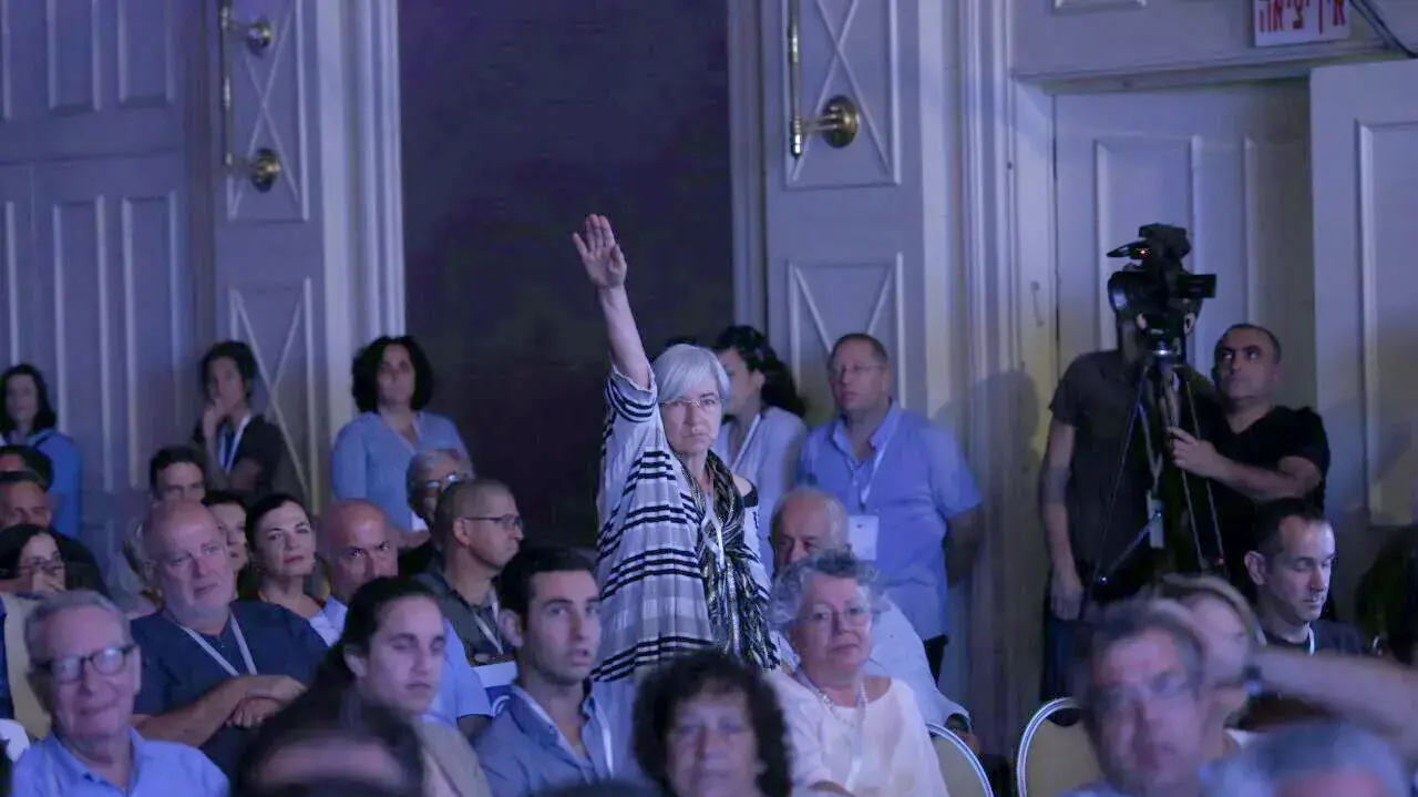אישה מצביעה במועל יד כשבנט מדבר במהלך ועידת הארץ לשלום 12 ביוני 2017 אישה מצביעה במועל יד כשבנט מדבר במהלך ועידת הארץ לשלום 12 ביוני 2017