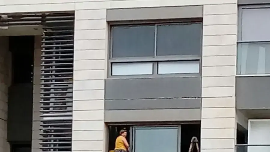 אישה מפתח תקווה מנקה את חלון ביתה בקומה -18 אישה מפתח תקווה מנקה את חלון ביתה בקומה -18
