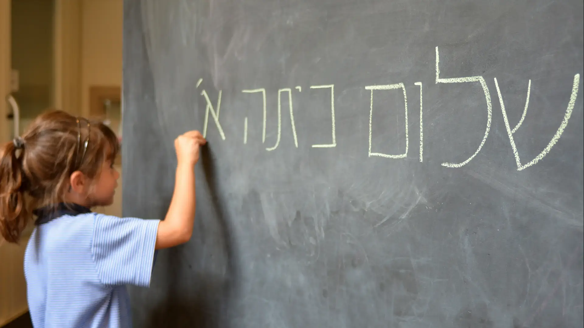 ילדה כותבת על לוח שלום כיתה א ילדה כותבת על לוח שלום כיתה א