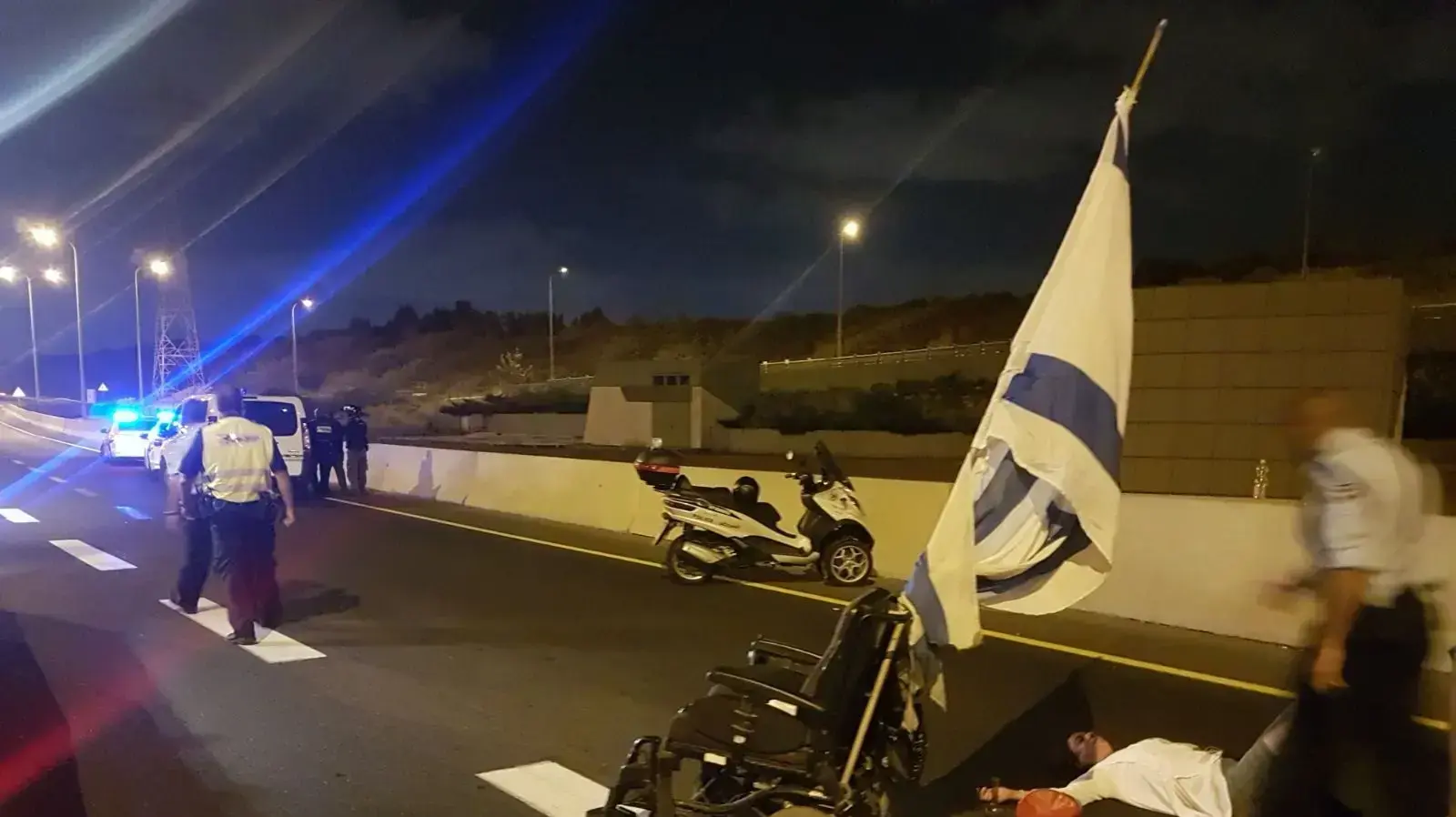 שוטרים גוררים פעילי מחאת הנכים באזור מחלף חולות, 4 באוקטובר 2017