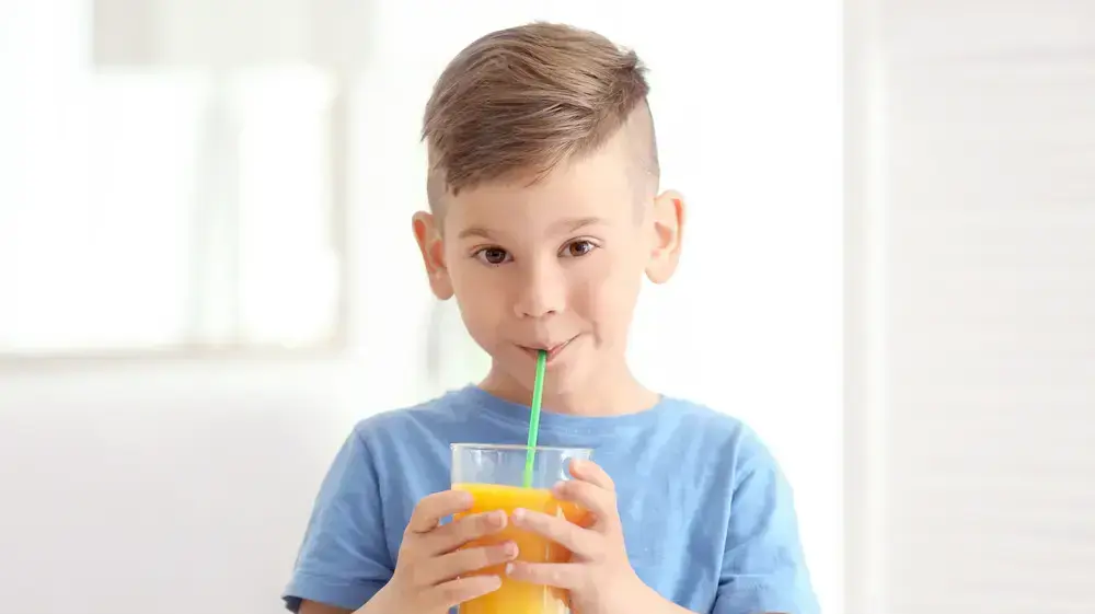 ילד שותה מיץ תפוזים בקשית ילד שותה מיץ תפוזים בקשית