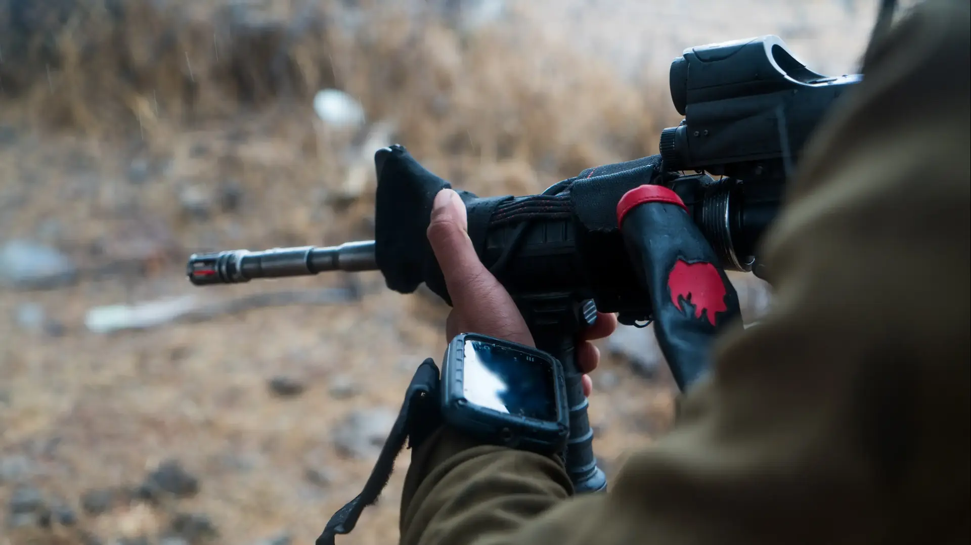 לוחם עונד את הטלפון החכם החדש של מפקדי מחלקות החי"ר ומכוון רובה לוחם עונד את הטלפון החכם החדש של מפקדי מחלקות החי"ר ומכוון רובה