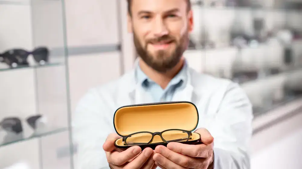 גבר מחזיק משקפי ראייה גבר מחזיק משקפי ראייה