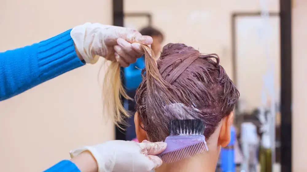 אישה צובעת את השיער במספרה אישה צובעת את השיער במספרה