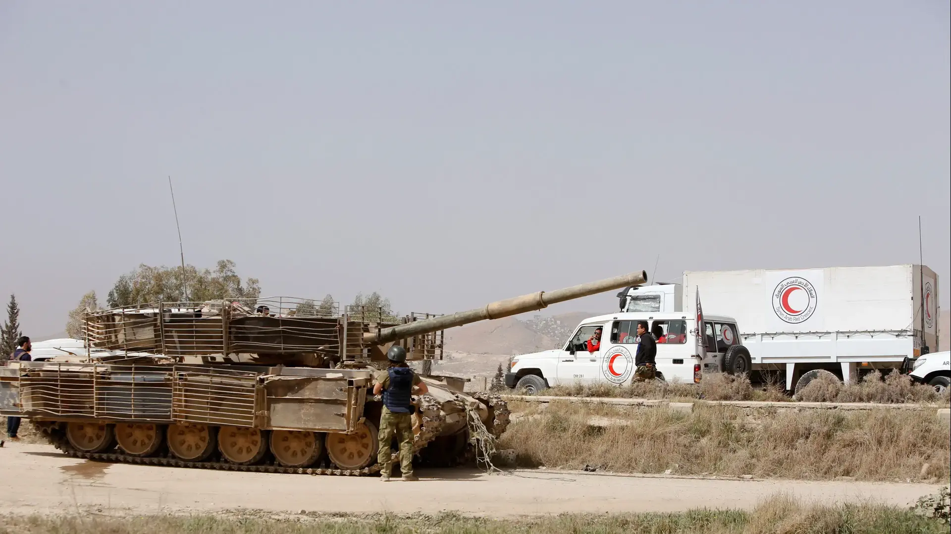 בכניסה לחראסה נראים טנקים צבאיים של הצבא הסורי ומשאית הסהר האדום מזרחית דמשק סוריה 22 במרץ 2018