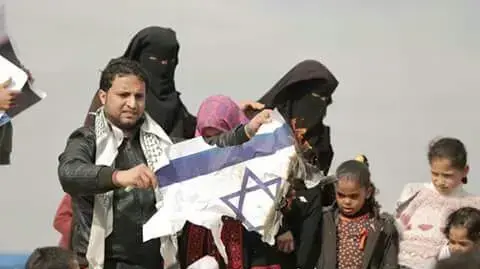 פלסטינים דורכים וקורעים שלטים עם תמונות ארה"ב, יוישראל באיזור האוהלים על גבול רצועת עזה, 30 במרץ 2018 פלסטינים דורכים וקורעים שלטים עם תמונות ארה"ב, יוישראל באיזור האוהלים על גבול רצועת עזה, 30 במרץ 2018