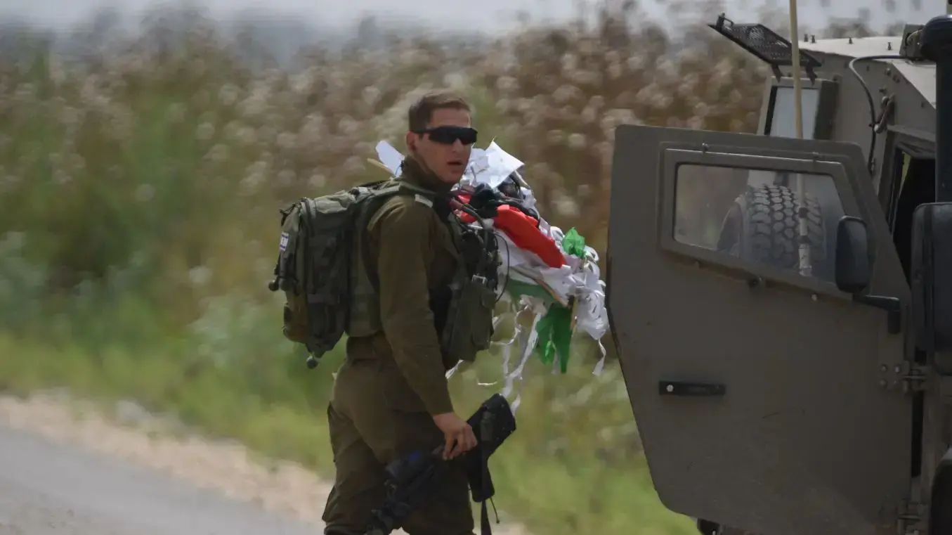 חייל מחזיק עפיפון שהועף מעבר לגדר המערכת ברצועת עזה, 20 באפריל 2018 חייל מחזיק עפיפון שהועף מעבר לגדר המערכת ברצועת עזה, 20 באפריל 2018
