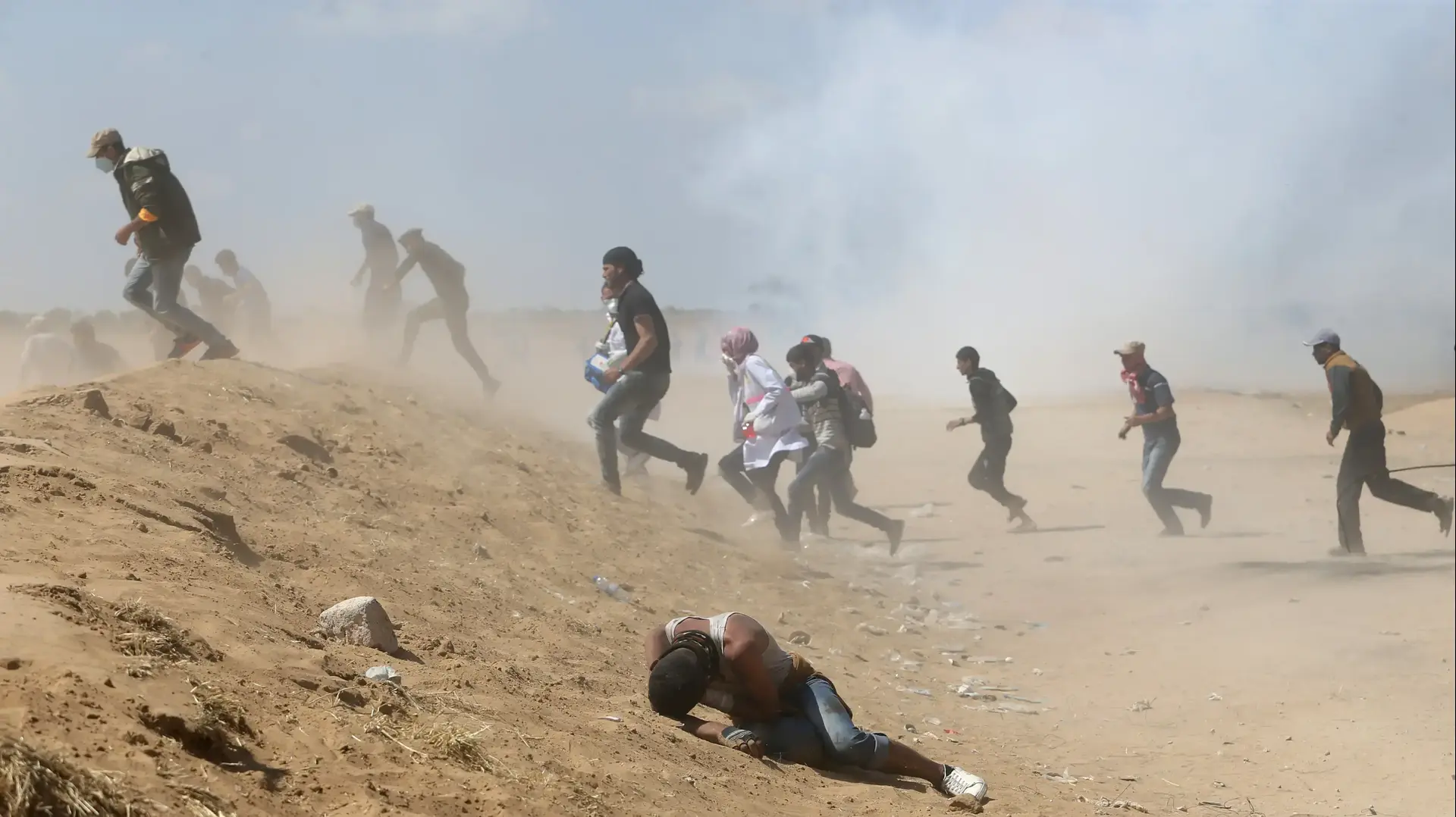 מפגינים בעזה נמלטים מגז מדמיע, 15 במאי 2018 מפגינים בעזה נמלטים מגז מדמיע, 15 במאי 2018