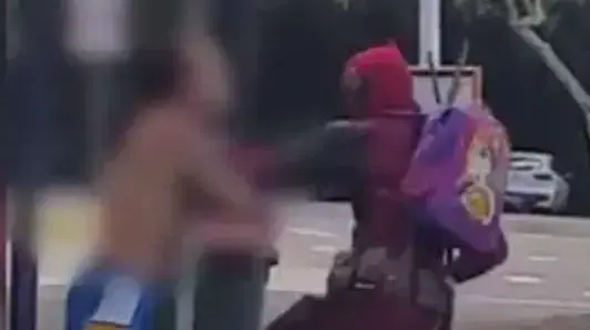 אדם בתחפושת דדפול הולך מכות ברחוב