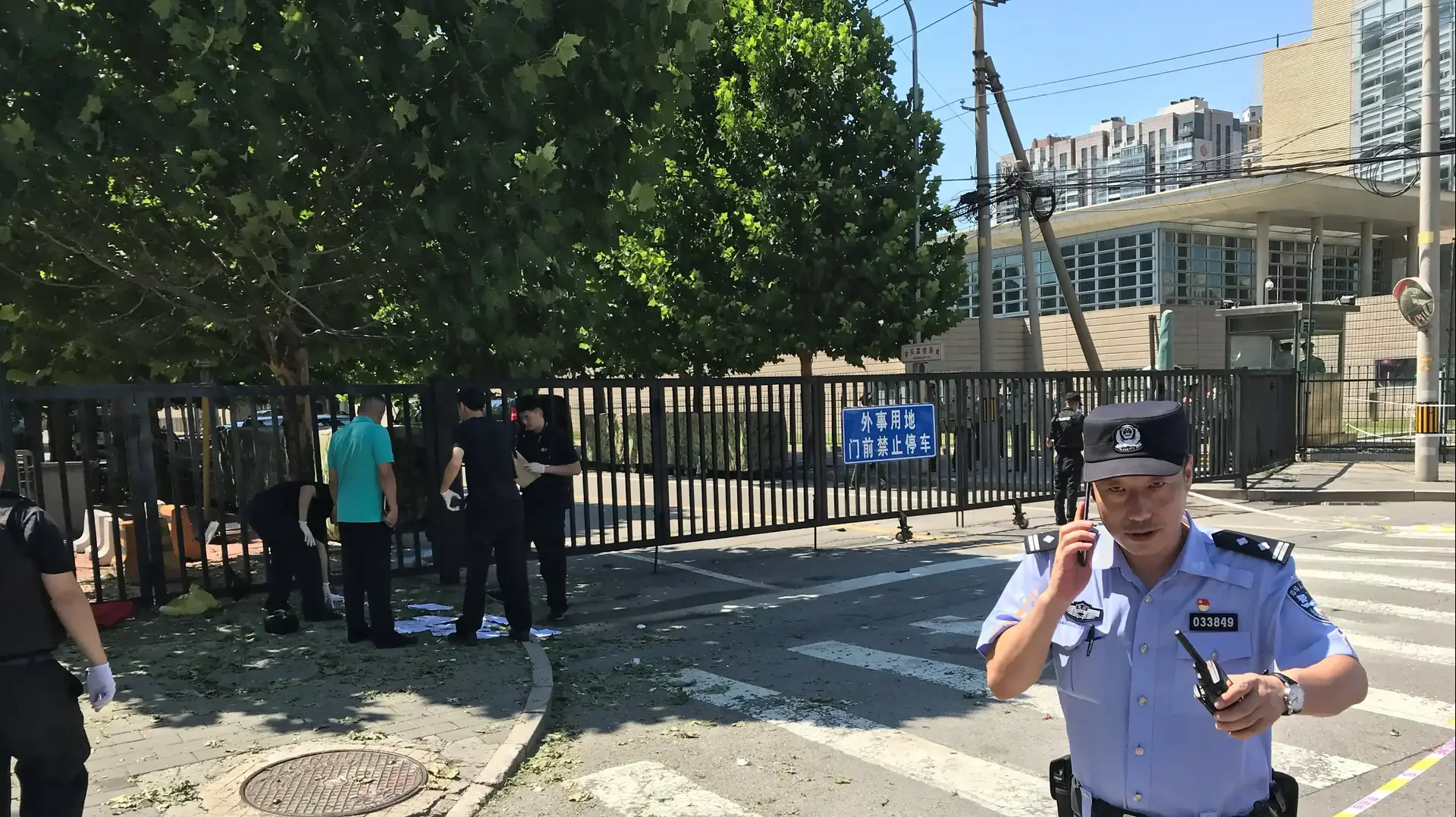 שוטר מחוץ לבניין שגרירות ארצות הברית בבייג'ינג בירת סין, לאחר שאישה ניסתה להצית את עצמה במקום, 26 ביולי 2018 שוטר מחוץ לבניין שגרירות ארצות הברית בבייג'ינג בירת סין, לאחר שאישה ניסתה להצית את עצמה במקום, 26 ביולי 2018