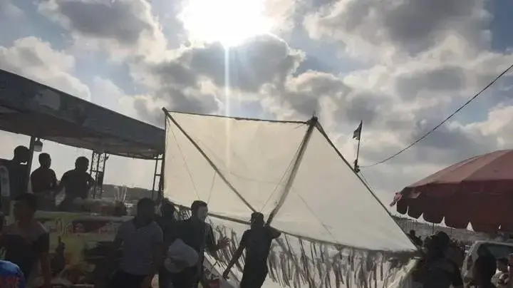 מפגינים פלסטינים נושאים עפיפון תבערה באזור גדר המערכת בגבול עזה, 3 באוגוסט 2018 מפגינים פלסטינים נושאים עפיפון תבערה באזור גדר המערכת בגבול עזה, 3 באוגוסט 2018