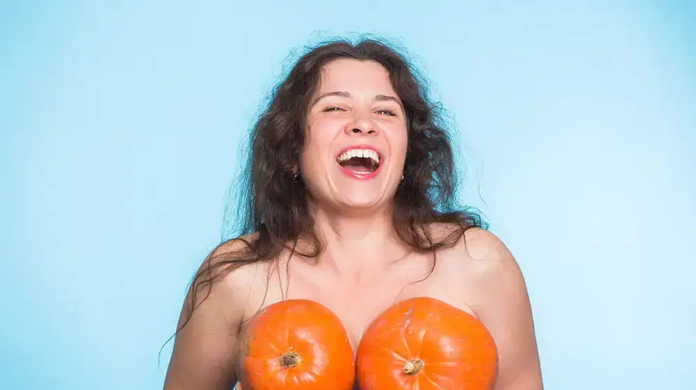 אישה מחזיקה דלעת מול החזה אישה מחזיקה דלעת מול החזה