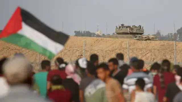 מפגינים פלסטינים על רקע טנק צה"לי במהלך ההפגנות ברצועת עזה 5 באוקטובר 2018
