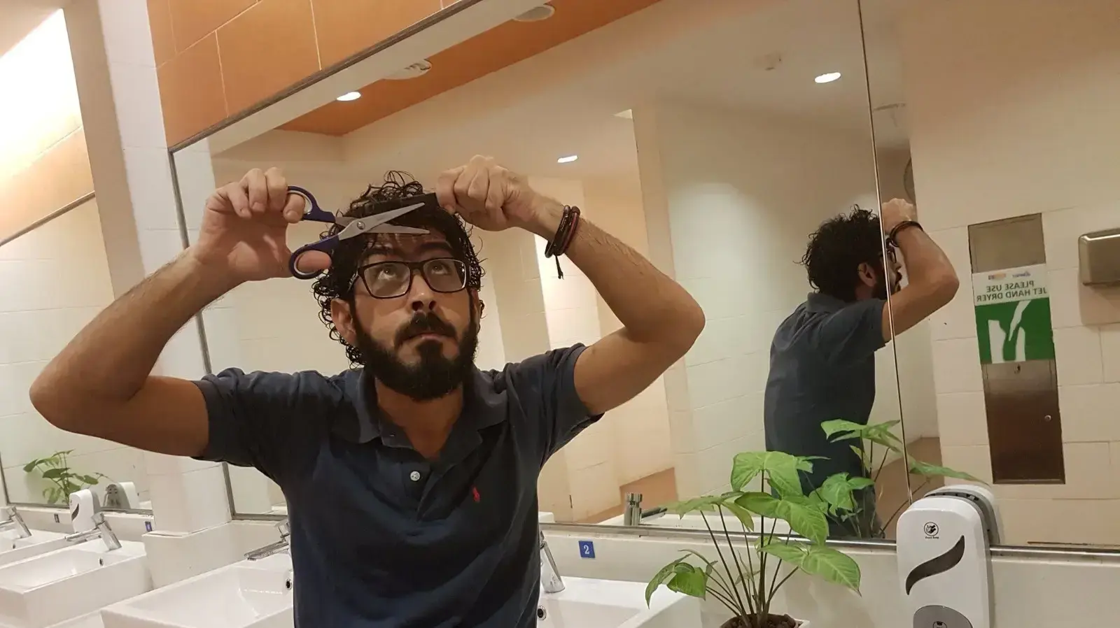 פליט סורי מסתפר בשירותי נמל התעופה במלזיה, אוגוסט 2018 פליט סורי מסתפר בשירותי נמל התעופה במלזיה, אוגוסט 2018