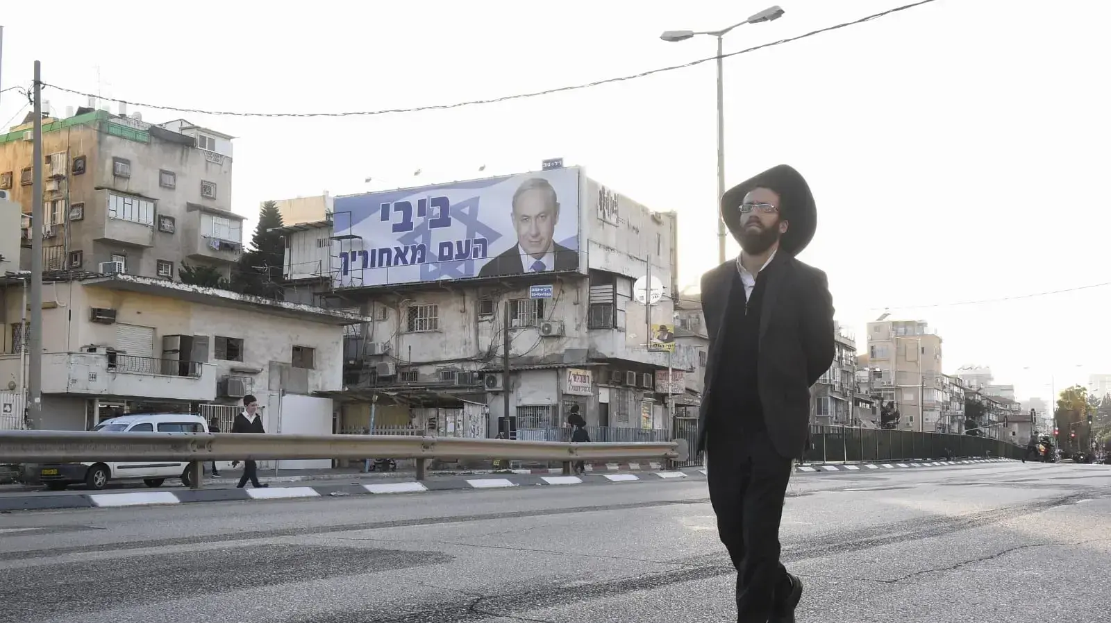 מפגין צועד על הכביש ומאחוריו שלט תמיכה בבנימין נתניהו בבני ברק 10 בדצמבר 2018 מפגין צועד על הכביש ומאחוריו שלט תמיכה בבנימין נתניהו בבני ברק 10 בדצמבר 2018