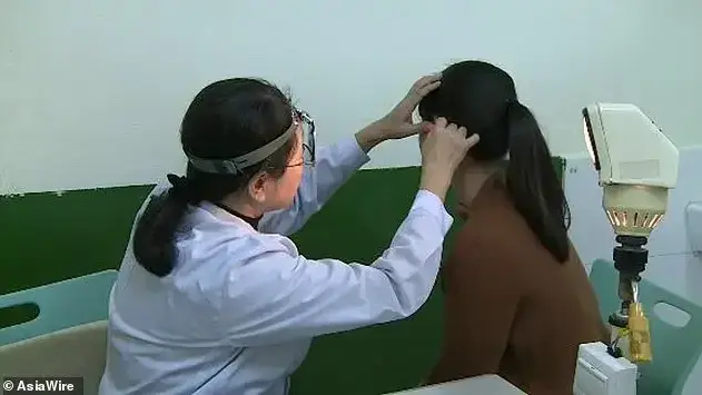 רופאה סינית בודקת אוזן של מטופלת רופאה סינית בודקת אוזן של מטופלת