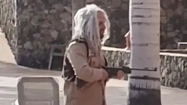 עובד בית מלון בספרד חבוש פאה מסתובב עם נשק בין האורחים