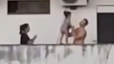 על המעקה של הקומה השביעית, הילדה מטיילת בליווי הוריה