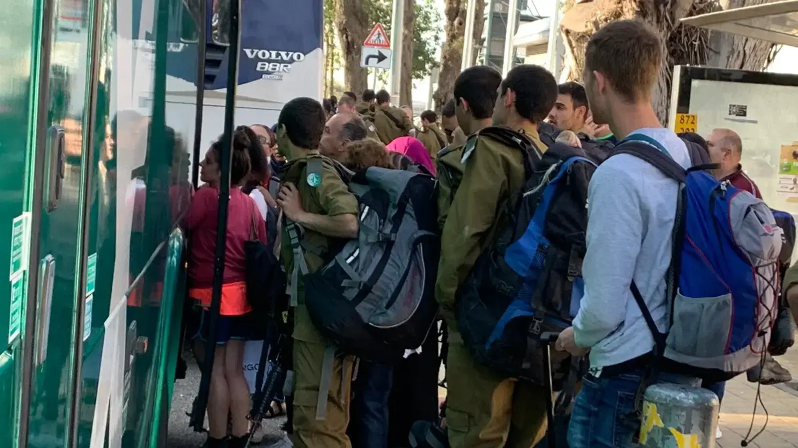 חיילים ואזרחים עולים לאוטובוס מחוץ לתחנת בנימינה, לאחר שנסגרה בעקבות שביתת ההנהלה