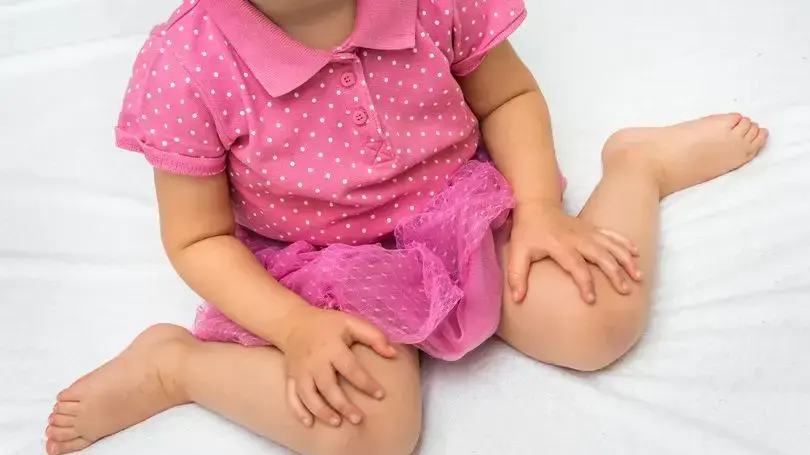 ילדה יושבת בתנוחת W