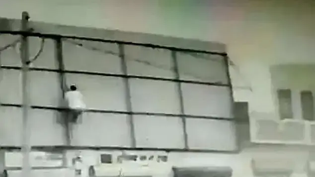 אדם עף באוויר כשהוא אוחז בקורה תומכת של גג
