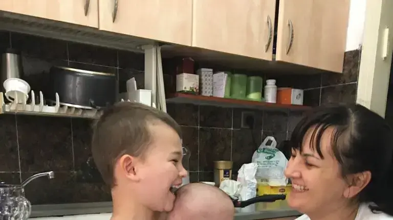 טימופי אשורטיה עם אחיו התינוק דו ועם אמו אוקסנה, יום לפני שהדרדר מחוף בבת ים, יוני 2019 טימופי אשורטיה עם אחיו התינוק דו ועם אמו אוקסנה, יום לפני שהדרדר מחוף בבת ים, יוני 2019