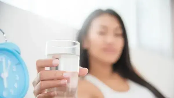 אשה שותה כוס מים אשה שותה כוס מים