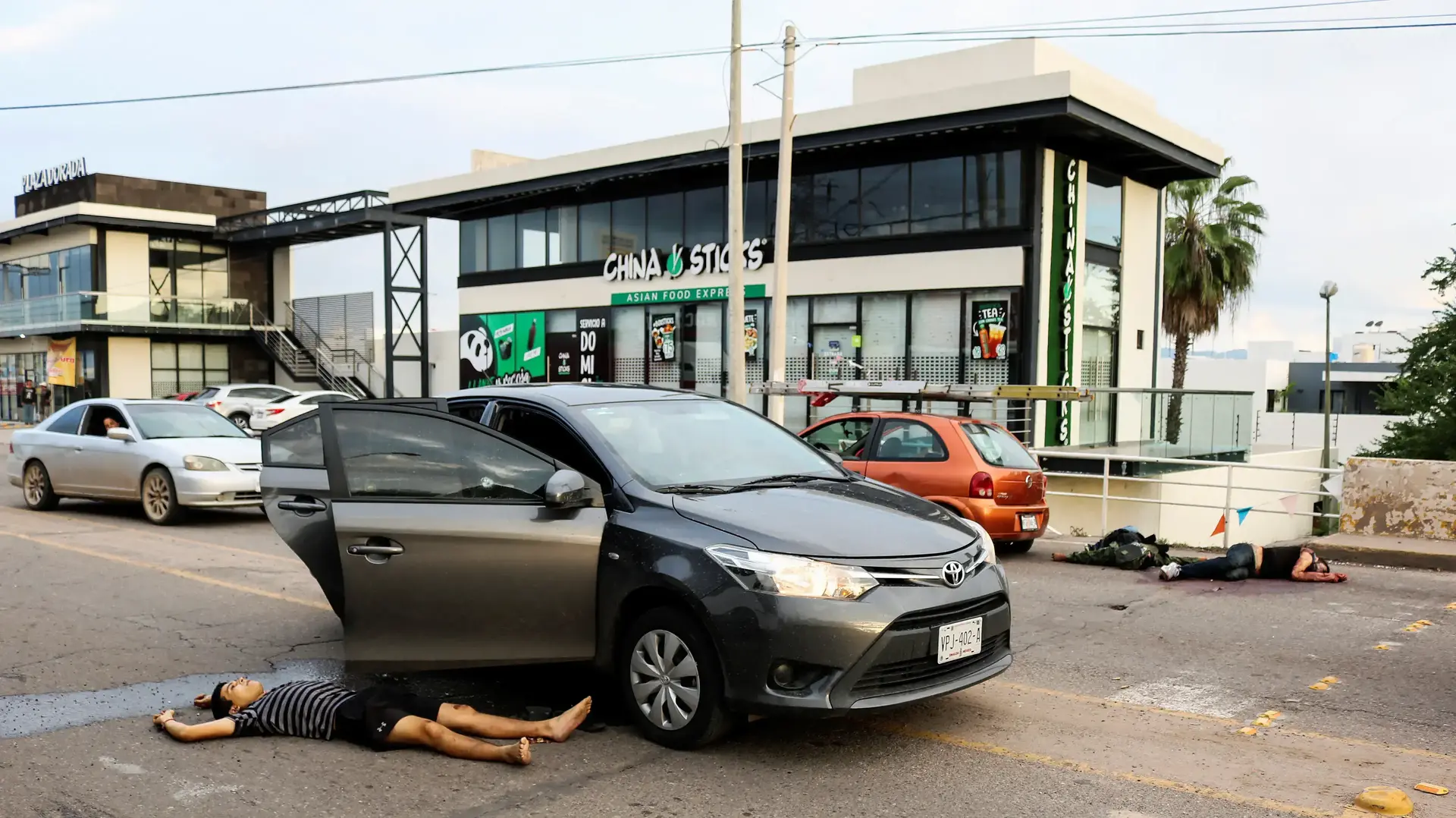 גופות שרועות ברחוב אחרי עימותים בין כוחות הביטחון לחמושים בעקבות מעצר בנו של אל צ'אפו, בעיר קוליאקאן, מקסיקו, 17 באוקטובר 2019