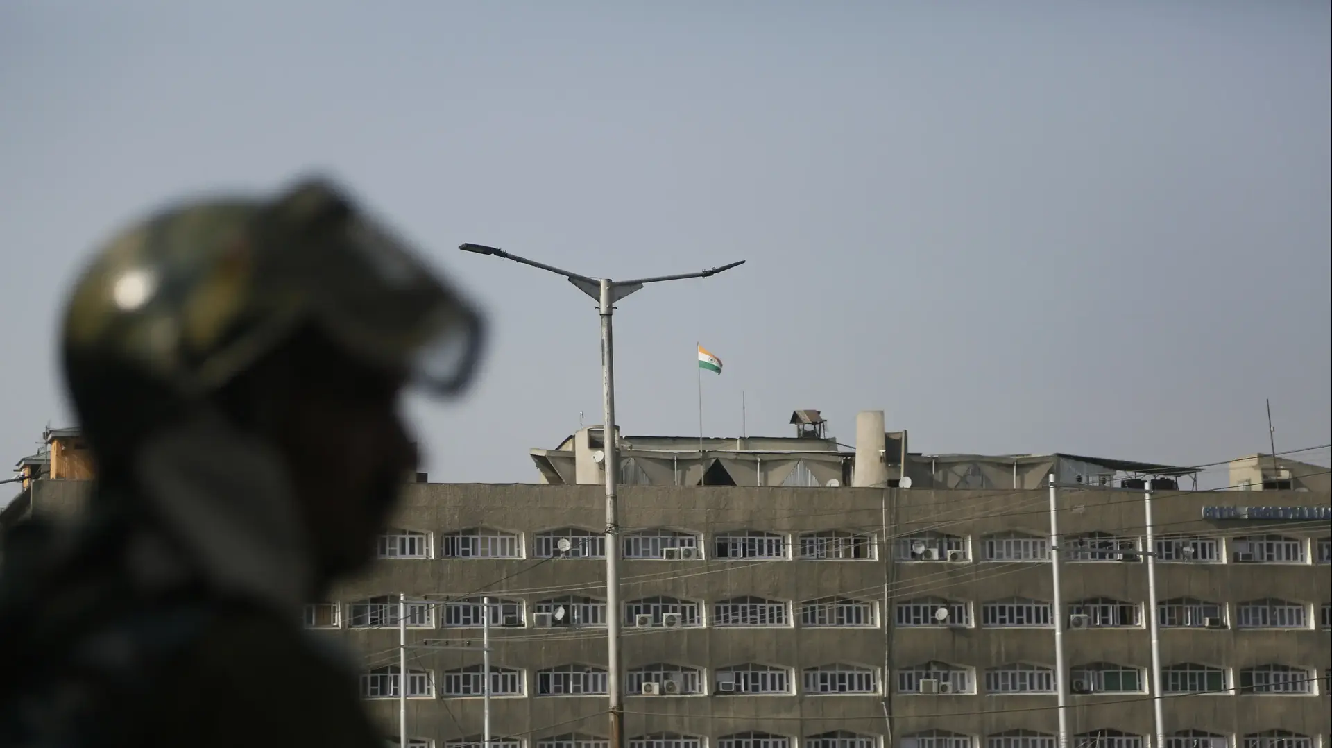 חייל הודי שומר סמוך למזכירות הממשלה בסרינגאר שבקשמיר כשהדגל הלאומי מתנפנף ברקע ב-31 באוקטובר 2019
