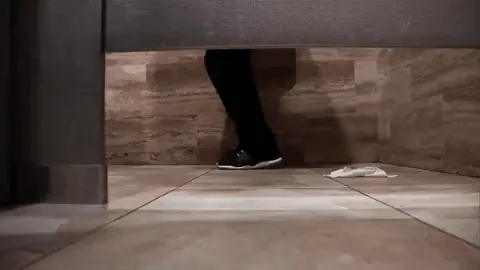 רגליים של גבר מתאפק לפיפי בתא שירותים רגליים של גבר מתאפק לפיפי בתא שירותים
